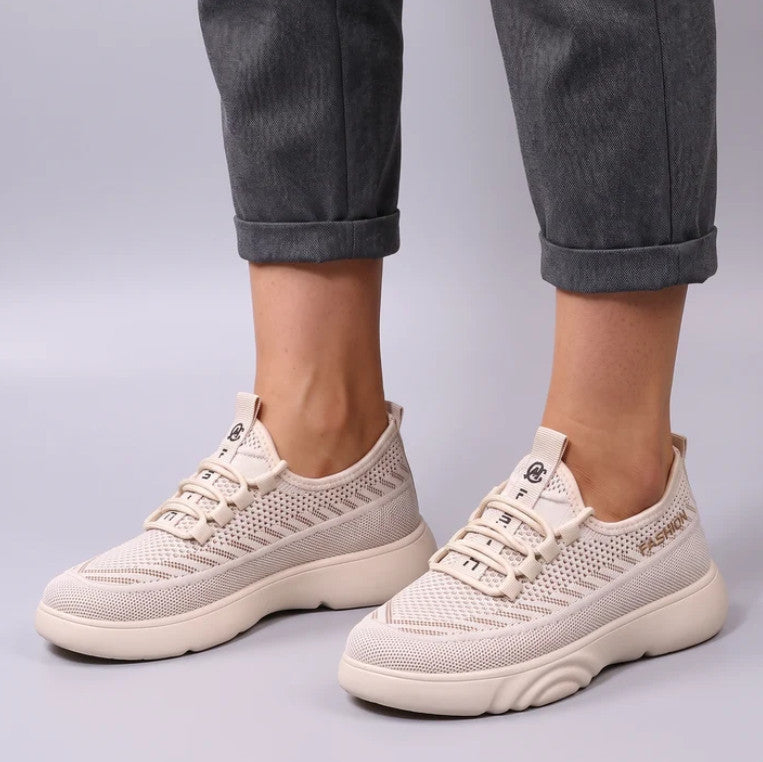 Evelyn Trainers in cream, worn with grey trousers