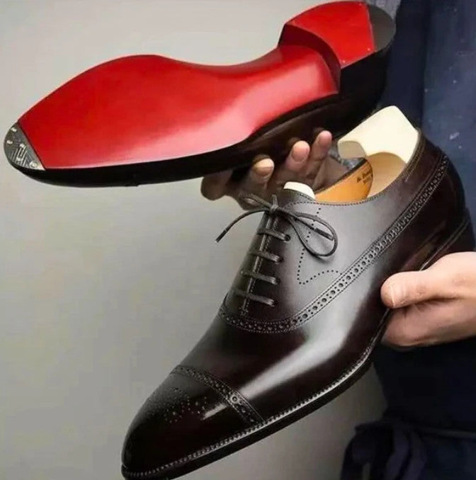 Ravello Oxford Brogues in brown, held in hand, sole detail